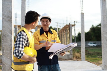 A diverse group of architects, engineers, and business professionals exchange a handshake indoors, symbolizing teamwork, success, and cooperation in a construction industry agreement.