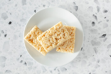 A top down view of a stack of crispy rice squares, on a plate.