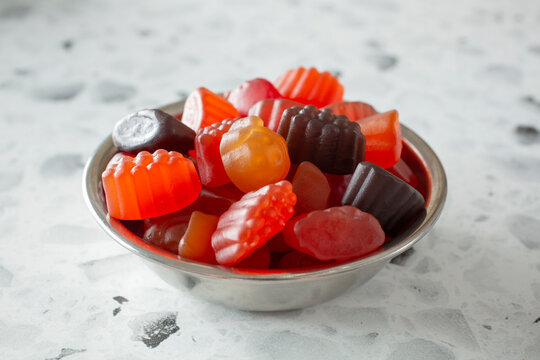 A closeup view of a small bowl of fruit gummy candy.
