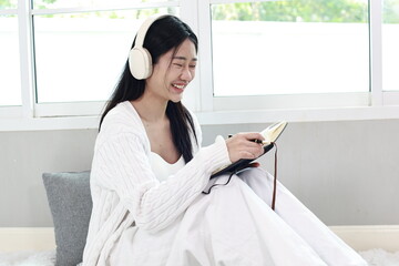 A cheerful woman relaxes on a cosy sofa in her modern apartment, enjoying her weekend with a smile...