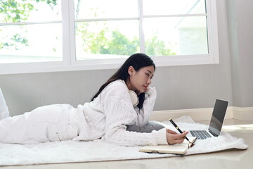 A cheerful woman relaxes on a cosy sofa in her modern apartment, enjoying her weekend with a smile...