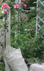 つるバラの庭と木製の椅子