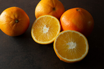 A view of a group of navel oranges, featuring one that is halved.