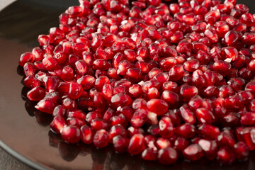 A closeup view of a pile of pomegranate arils on a plate.