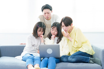 困った表情でパソコンを使う家族