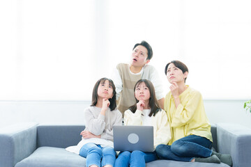困った表情でパソコンを使う家族