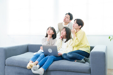 困った表情でパソコンを使う家族