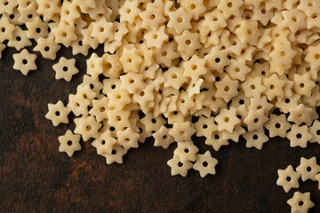 A top down view of a pile of dry star shaped pasta.