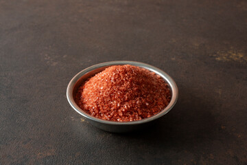 A view of a condiment cup of Hawaiian red salt.