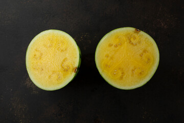 A top down view of a halved mini yellow seedless watermelon.