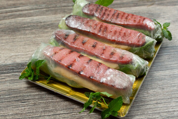 A view of a plate of pork paste spring rolls.