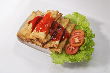 Lumpia with sweet and sour sauce. Spring roll dish with sauce topping