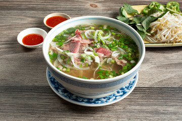 A view of a bowl of rare steak pho.