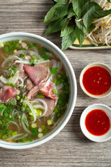 A top down view of a bowl of rare steak pho.