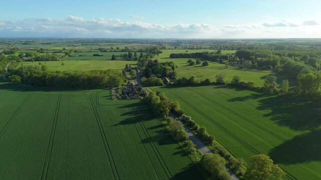 Aerial drone rural green agriculture landscape rapeseed England UK Spring summer Sunshine evening motorway roads countryside 