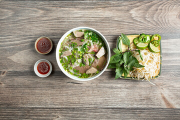 A top down view of a bowl of pho dac biet.