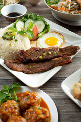 A view of a plate of broken rice, featuring BBQ short rib, among other entrees.