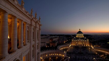 Evening view of the Vatican City with glowing lights highlighting classical baroque columns, marble statues, and elegant architectural details against a deep blue twilight sky