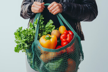 Minimal people holding reusable grocery shopping bag filled with fresh organic fruit and vegetable. Sustainable lifestyle.