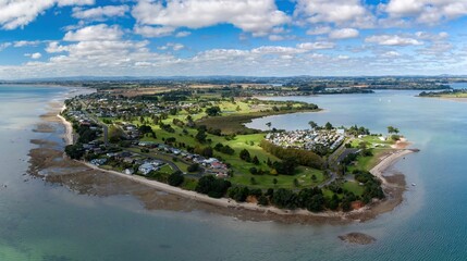 Aerial view of a coastal community of Clarks Beach, Auckland, New Zealand. Homes line the shore,...