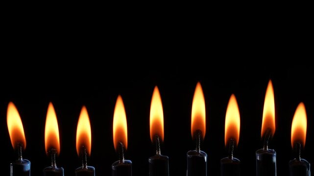 Nine Lit Candles in a Row Against Black Background