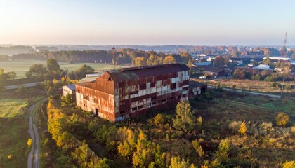Abandoned Rustic Warehouse Surrounded by Autumn Landscape at Dawn