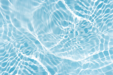 Blue water with ripples on the surface. Defocus blurred transparent blue colored clear calm water surface texture with splashes and bubbles. Water waves with shining pattern texture background.