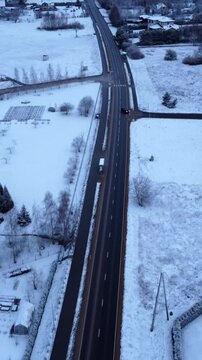 A birdseye view of a street winding through snowy winter landscapes, showcasing the serene, frozen scenery.