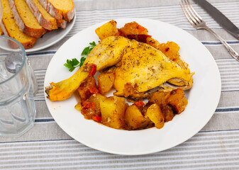 Chicken with fried potatoes laid out on plate in restaurant