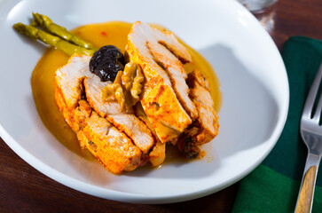 Delicious poultry dish - baked turkey breast with prunes, walnut and spicy sauce on plate