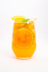 refreshing orange citrus cocktail with sliced lemon and mint leaves served in clear glass over ice on white background. High quality photo