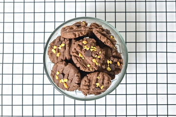 Top view of cookies with peanut and chocolate chips in glass bowl isolated on white background. Freshly Baked Homemade. perfect for bakery advertisements and dessert menus. Napkin. Baking rack. Above.