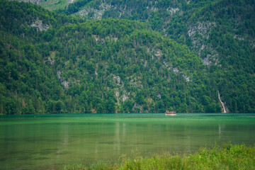 Konigssee Lake in Bavaria Germany with Church by the Lake White Boat Forested Mountain and Beautiful Sunny Trekking in Berchtesgaden German Alps. High quality photo