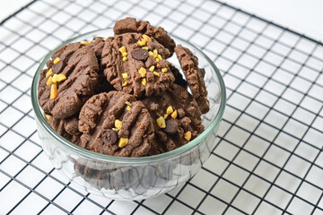 Close up view of cookies with peanut and chocolate chips in glass bowl isolated on white background. Freshly Baked Homemade. perfect for bakery advertisements and dessert menus. Baking rack.