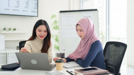 Muslim Business Women Collaboration Asian Women Discussing Ideas on Laptop in Modern Office Diverse Teamwork Startup Success in Islamic Finance