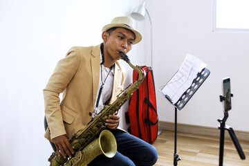 Portrait Of Saxophonist Playing A Music While Recording Vlog Using Smartphone At Music Studio