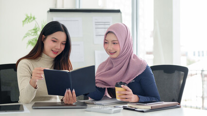 Asian Women Discussing Muslim Business Ideas in Office with Hijab Smiling and Brainstorming for...