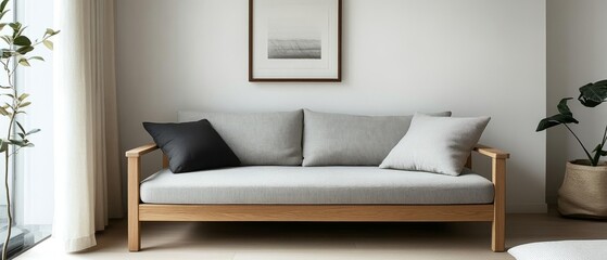 Minimalist living room with a light grey fabric sofa with wooden arms, neutral-toned pillows, and a simple framed print, enhanced by soft lighting and calming neutral colors.
