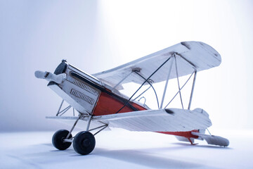 Vintage toy biplane evoking nostalgia and adventure on a white background of light and shadows