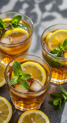 Refreshing iced lemon mint tea glasses top down view on cool stone table closeup