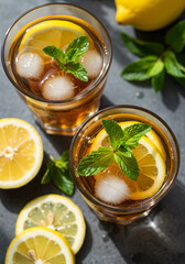 Refreshing iced lemon mint tea glasses top down view on cool stone table closeup