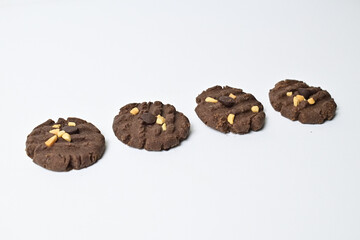 Photo of four cookies with peanut and chocolate chips. Freshly Baked Homemade. perfect for bakery advertisements and dessert menus. Clipping path. Close up. Isolated on white background.