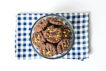 Top view of cookies with peanut and chocolate chips in glass bowl isolated on white background. Freshly Baked Homemade. perfect for bakery advertisements and dessert menus. Napkin. Close up. Above.