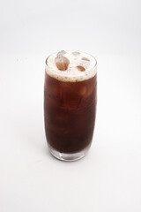 iced coffee or cold brew in tall clear glass with ice cubes and creamy foam served on white background. High quality photo
