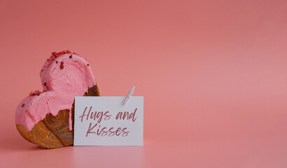 Birthday Valentine's day HUGS AND KISSES wishes saying caption on greeting card Delightful and vibrant heartshaped pastry croissant treat, beautifully topped with colorful frosting galore. Copy space