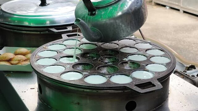 Khanom Khrok is a traditional Thai coconut-rice pancake, famous for its sweet, creamy, and slightly crispy texture. It is cooked in a special cast-iron pan with small round molds