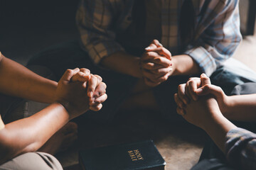 Close up group christians hands pray to God with spiritual faith on holy bible in catholic church....