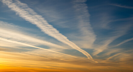 Contrails in the sky at sunset