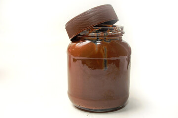 chocolate spread jar seen from the side, lid open, isolated on white background