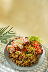 Delicious Indonesian fried rice served with colorful crackers, fresh lettuce, tomato slices, and chili garnish. Traditional Asian meal perfect for food blog, menu, or culinary content.
